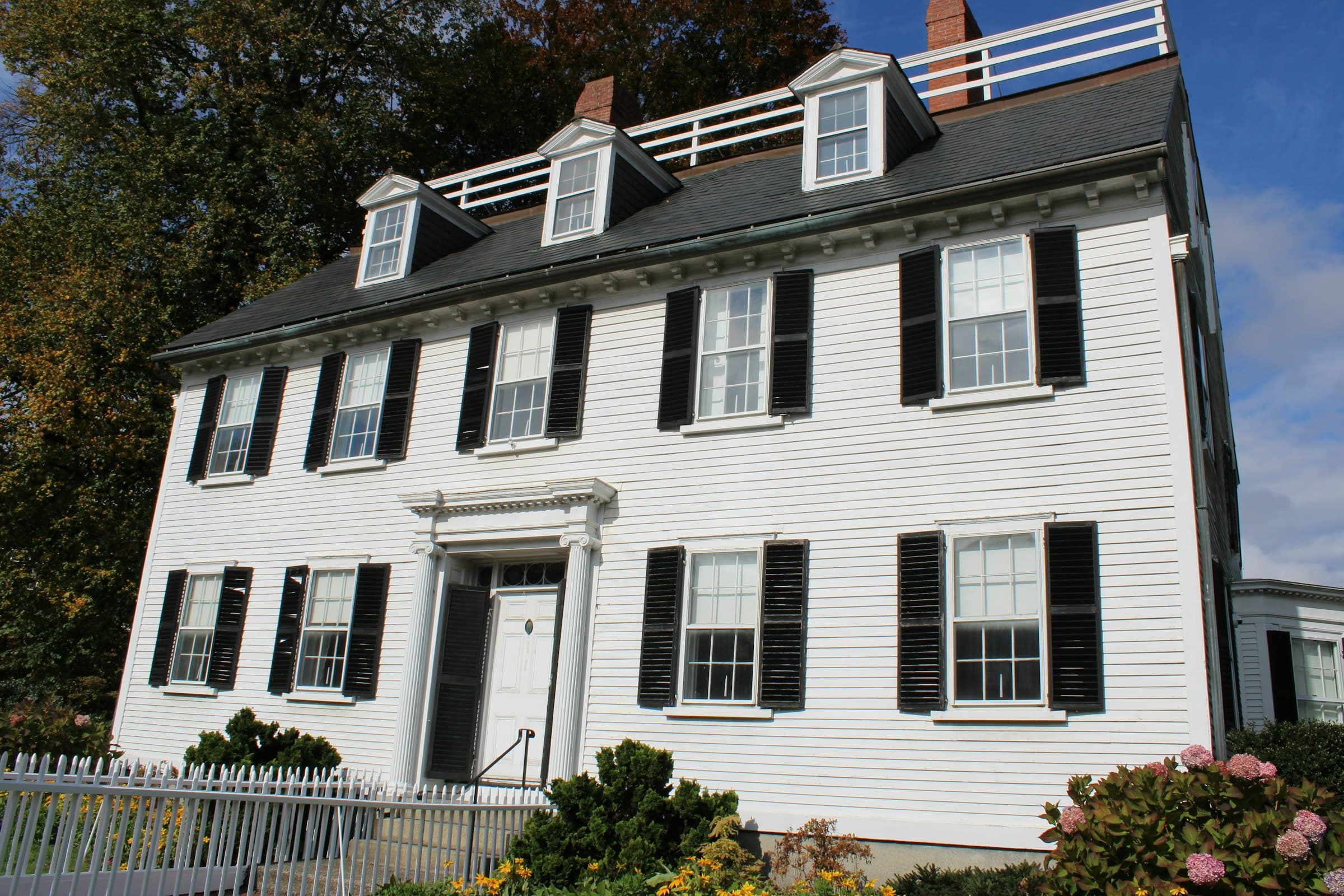 White colonial home with black shutters and freshly cleaned windows on a sunny day in Tuxedo, NY